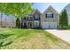Charming two-story home with manicured lawn, attached two-car garage, and brick and vinyl siding at 7719 Whisperingwood Dr, Harrisburg, NC 28075