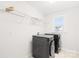 Efficient laundry room featuring modern washer and dryer, overhead shelving, and a bright window at 8005 Rolling Wheels Rd, Charlotte, NC 28215