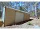 View of the metal outbuilding with a sliding door surrounded by trees in a wooded area at 816 Osteen Rd, York, SC 29745