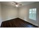 Bedroom with dark wood floors, ceiling fan, and a window with a view of the outdoors at 8704 Moody Rd, Charlotte, NC 28215