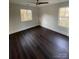 Bedroom with dark wood floors, ceiling fan, and two windows with a view of the outdoors at 8704 Moody Rd, Charlotte, NC 28215