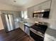 Modern kitchen with stainless steel appliances, granite countertops, gray cabinets, and a stylish tile backsplash at 8704 Moody Rd, Charlotte, NC 28215