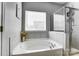 Bathroom featuring a tiled shower, soaking tub, and a large bright window at 100 Marabou Ct, Mount Holly, NC 28120