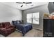 Cozy bedroom featuring a ceiling fan, bright window, and comfortable armchair at 100 Marabou Ct, Mount Holly, NC 28120