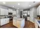 Bright kitchen with white cabinets, stainless steel appliances, and a granite-topped island at 100 Marabou Ct, Mount Holly, NC 28120