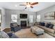 Cozy living room featuring a fireplace, plush seating, and a ceiling fan at 100 Marabou Ct, Mount Holly, NC 28120