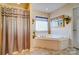 The bathroom has a soaking tub and decorative window with glass blocks at 10202 Little Whiteoak Rd, Charlotte, NC 28215