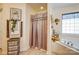 Neutral bathroom with decorative wall art, curtained shower, tub and decorative accent items at 10202 Little Whiteoak Rd, Charlotte, NC 28215