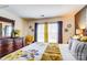 Sunlit bedroom with bed, dresser and decorative accents at 10202 Little Whiteoak Rd, Charlotte, NC 28215