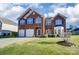 Charming two-story red brick home with blue shutters and green lawn at 10202 Little Whiteoak Rd, Charlotte, NC 28215