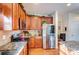 Modern kitchen with stainless steel appliances, granite countertops, and wooden cabinets at 10202 Little Whiteoak Rd, Charlotte, NC 28215