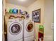 Bright laundry room featuring modern LG washer and dryer set with storage shelf and wall art at 10202 Little Whiteoak Rd, Charlotte, NC 28215