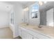 Bathroom featuring a double sink vanity, large mirror, and a separate room, showcasing functionality and design at 11331 Breezehill Ln, Charlotte, NC 28262