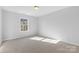 Bright bedroom with neutral carpet, ample natural light streaming through a large window, and electrical outlets at 11331 Breezehill Ln, Charlotte, NC 28262