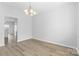 Clean, freshly painted dining room featuring modern light fixture and light laminate flooring at 11331 Breezehill Ln, Charlotte, NC 28262