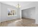 Bright dining room with large windows and light laminate floors, connected to another room at 11331 Breezehill Ln, Charlotte, NC 28262