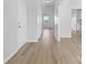 Bright hallway with modern laminate floors, white walls, and natural light from a window at the end at 11331 Breezehill Ln, Charlotte, NC 28262