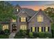 Charming brick two-story home featuring manicured landscaping, symmetrical design, and warm interior lighting peeking through the windows at 120 Shadow Ridge Ct, Statesville, NC 28677