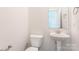 Powder room with sleek pedestal sink, mirror, and fixtures at 131 Jacobs Hill Pl, Troutman, NC 28166