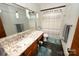 Bathroom with granite countertops, modern mirror, and stylish shower curtain at 1793 Fairway Dr, Newton, NC 28658