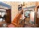 Welcoming foyer features tile flooring, a wooden staircase, and a charming floral wallpaper design at 1793 Fairway Dr, Newton, NC 28658