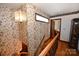 Hallway features wooden railings, floral wallpaper, and hardwood floors leading to a bedroom at 1793 Fairway Dr, Newton, NC 28658