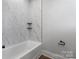 Modern bathroom featuring a white marble-look tile surround, a deep soaking tub, matte black fixtures, and open shelving at 2081 Fordhill St, Rock Hill, SC 29732