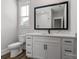 Bright bathroom featuring a white vanity with marble countertop, a black framed mirror, and wood-look vinyl plank flooring at 2081 Fordhill St, Rock Hill, SC 29732