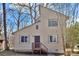 Two-story home featuring neutral siding, a simple front door, and a small entry porch and is nestled in a wooded setting at 2406 Brook Canyon Dr, Charlotte, NC 28212