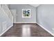 Bright living room with fresh gray paint, hardwood floors, and abundant natural light from the large window at 2406 Brook Canyon Dr, Charlotte, NC 28212