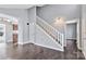 View of the living room featuring hardwood floors, light gray walls, and staircase to the upper level at 2406 Brook Canyon Dr, Charlotte, NC 28212