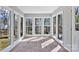 Sunroom with brick floors and lots of light from the abundant windows providing views of the wooded yard at 2406 Brook Canyon Dr, Charlotte, NC 28212