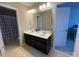 Bathroom featuring double sink vanity, dark wood cabinets, tile flooring, and shower with patterned curtain at 2640 Southern Trace Dr, Waxhaw, NC 28173