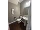 Cozy powder room with pedestal sink, decorative mirror, stylish fixtures and wood flooring at 2640 Southern Trace Dr, Waxhaw, NC 28173