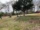 Large backyard with mature trees and a glimpse of a single story brick home at 356 Lucky Hollow Rd, Hickory, NC 28601