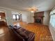 Open-concept living room with hardwood floors, brick fireplace, and connecting rooms with great natural light at 356 Lucky Hollow Rd, Hickory, NC 28601