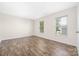 A bedroom features wood-look floors and bright, natural light from two large windows at 4528 Potters Glen Rd, Charlotte, NC 28269