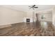 Spacious living room with a fireplace, fan, hardwood floors, and natural light at 4528 Potters Glen Rd, Charlotte, NC 28269