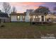 Large backyard with a deck, garden boxes, and mature trees, enhanced image at 5501 Joyce Dr, Charlotte, NC 28215