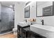 Sleek bathroom featuring double sink vanity, modern fixtures, walk-in shower, and tile flooring at 5501 Joyce Dr, Charlotte, NC 28215