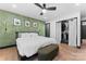 Stylish bedroom with a decorative accent wall, ceiling fan, curtains and walk-in closet at 5501 Joyce Dr, Charlotte, NC 28215