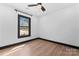 Bright bedroom featuring wood floors, a ceiling fan, and a window allowing natural light at 5501 Joyce Dr, Charlotte, NC 28215