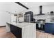 Modern kitchen with a waterfall island, stainless steel appliances, and floating shelves at 5501 Joyce Dr, Charlotte, NC 28215
