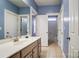 Bathroom features a vanity sink with a mirror and access to the tiled shower and toilet area at 5807 Mctaggart Ln, Charlotte, NC 28269