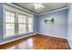 Cozy bedroom with hardwood floors, natural light, and a ceiling fan, offering comfort and style at 5807 Mctaggart Ln, Charlotte, NC 28269