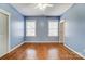 Bright bedroom with hardwood floors, two windows, and neutral paint, creating a calming and inviting space at 5807 Mctaggart Ln, Charlotte, NC 28269