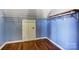 Cozy bedroom featuring hardwood floors, blue walls, and unique attic storage solutions at 5807 Mctaggart Ln, Charlotte, NC 28269