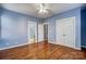 Bright bedroom features hardwood floors, a ceiling fan, and a double-door closet for ample storage at 5807 Mctaggart Ln, Charlotte, NC 28269