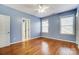 Bright bedroom features hardwood floors, a ceiling fan, and natural light from the double windows at 5807 Mctaggart Ln, Charlotte, NC 28269