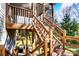 Outdoor wooden stairs leading to a deck, surrounded by lush greenery, offering a rustic and inviting entrance at 5807 Mctaggart Ln, Charlotte, NC 28269